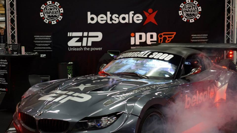 BMW Z4 racewagen in ZIP-kleuren met rokende banden tijdens een event